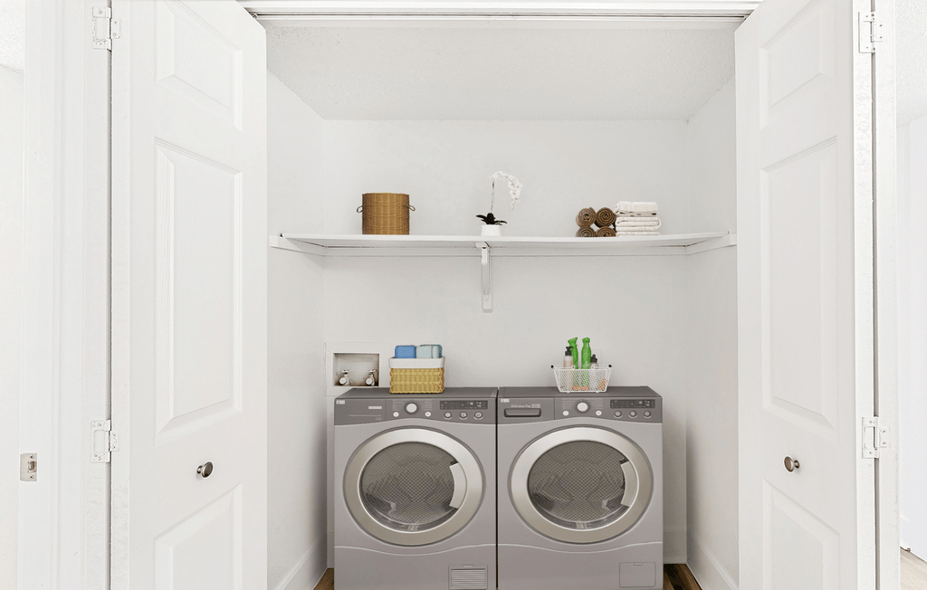 Virtually staged laundry room with stainless washer and dryer, shelf with towels and neatly organized items in baskets